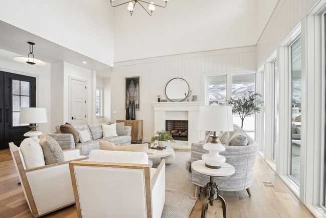 Living room featuring a wealth of natural light, light wood-type flooring, visible vents, and a fireplace | Image 8