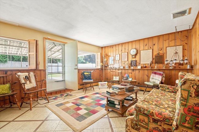 Living room featuring wooden walls and a baseboard heating unit | Image 20