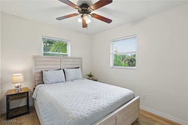 Bedroom with multiple windows, light wood-style floors, and ceiling fan | Image 23