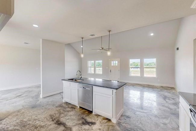 Kitchen with concrete floors, open floor plan, appliances with stainless steel finishes, and lofted ceiling | Image 11