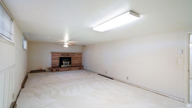 Unfurnished living room with ceiling fan, a glass covered fireplace, and light carpet | Image 17