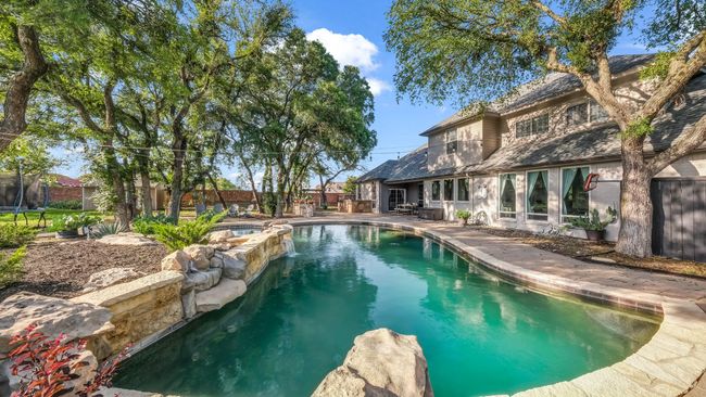 View of swimming pool with a fenced backyard, a patio area, and a pool with connected hot tub | Image 32
