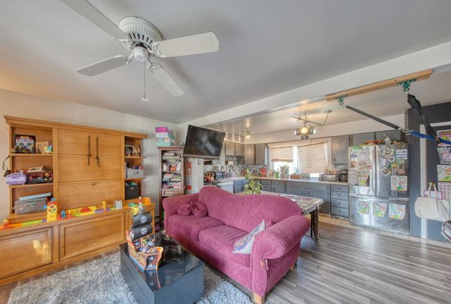 Living area with ceiling fan and light wood-style floors | Image 6