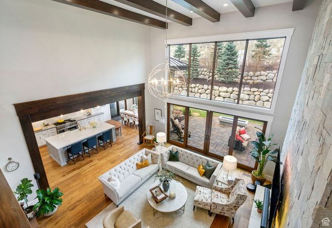 Living room with beamed ceiling, a towering ceiling, an inviting chandelier, and wood finished floors | Image 64
