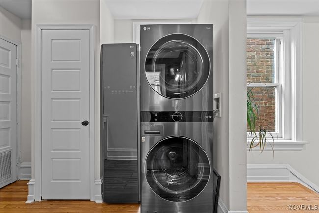 Laundry room featuring baseboards, wood finished floors, stacked washer / dryer, and laundry area | Image 32