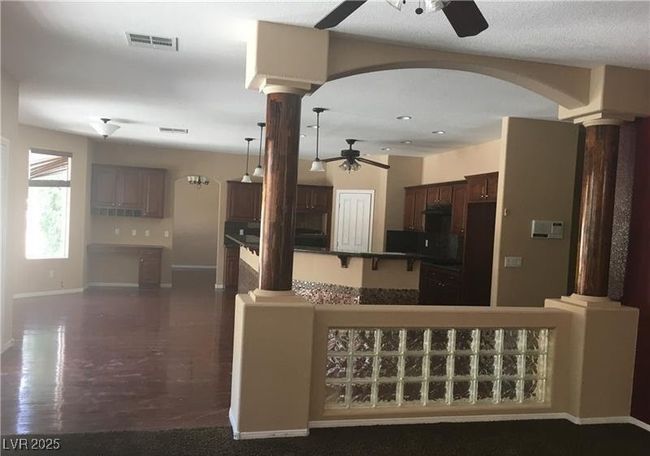 Kitchen featuring ceiling fan, decorative columns, dark brown cabinetry, arched walkways, and recessed lighting | Image 11
