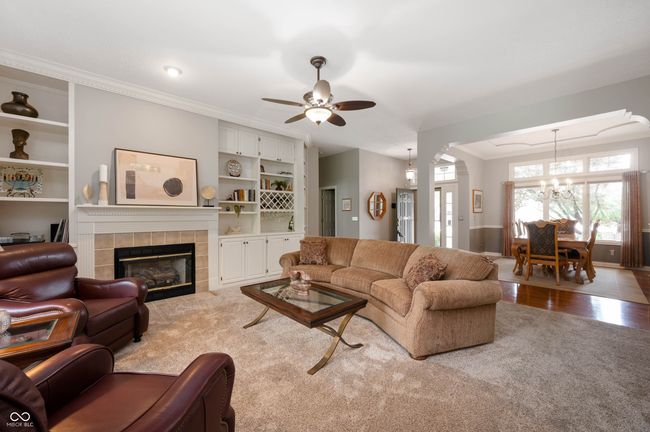 living room featuring a fireplace with built-in shelving and cabints | Image 5