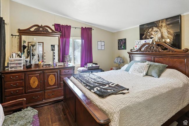 Bedroom featuring lofted ceiling, dark wood-type flooring, and crown molding | Image 10