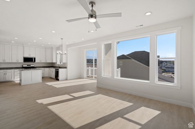 Unfurnished living room with light wood-style floors, a chandelier, recessed lighting, and ceiling fan | Image 4