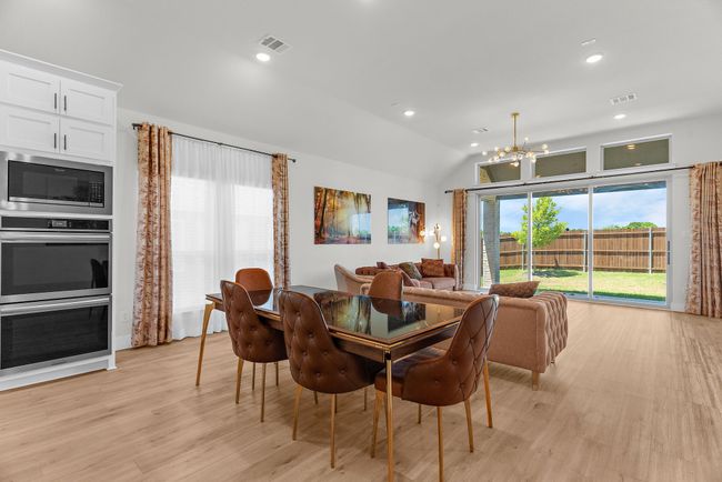 Dining area featuring a chandelier, light wood finished floors, vaulted ceiling, and recessed lighting | Image 17