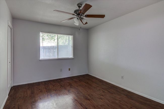 Empty room featuring wood finished floors, ceiling fan, and baseboards | Image 12