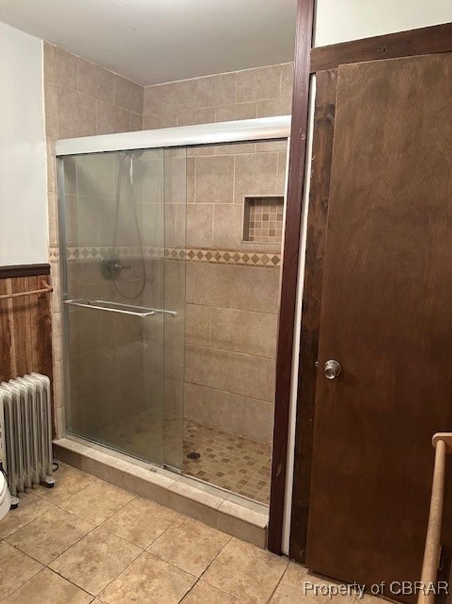 Full bathroom featuring radiator, a stall shower, and tile patterned flooring | Image 16