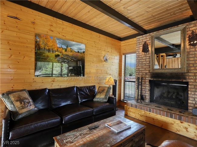 Living room with wood walls, wooden ceiling, beam ceiling, and wood finished floors | Image 8