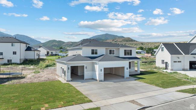 View of front facade featuring a mountain view, a residential view, a shingled roof, a front lawn, and concrete driveway | Image 32