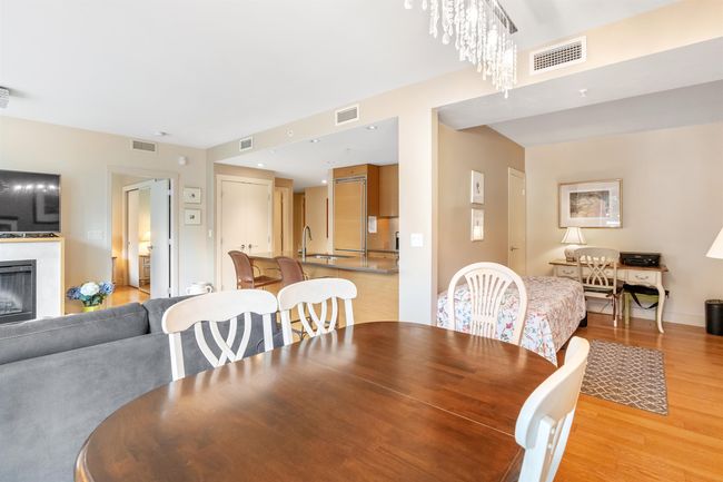 Dining room with a fireplace, light wood-style floors, and visible vents | Image 4