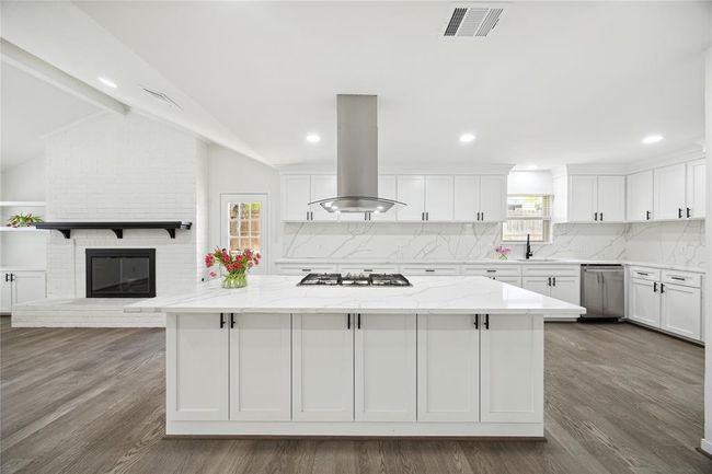 A closer view of the large island, complete with a gas range and vent hood. | Image 8
