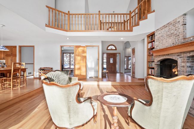 This reverse view of the great room shows the foyer straight ahead, a formal living room just to the right of the foyer, the eat-in kitchen is on the left, and above you will notice the upper level walkway where four of the bedrooms are located. | Image 5