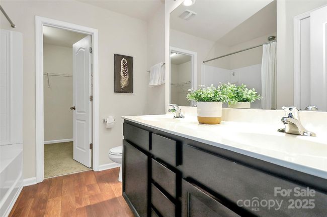 Primary bathroom with double vanity, large walk-in closet, and lovely garden tub. | Image 19