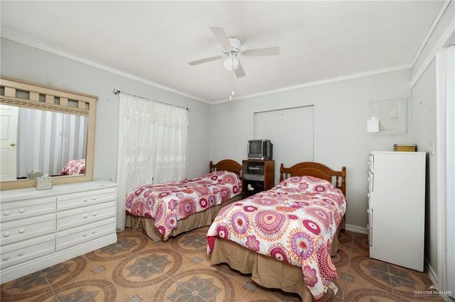Bedroom with ceiling fan and crown molding | Image 8