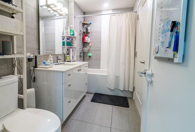 Full bathroom featuring tile patterned floors, shower / bath combination with curtain, toilet, and vanity | Image 14