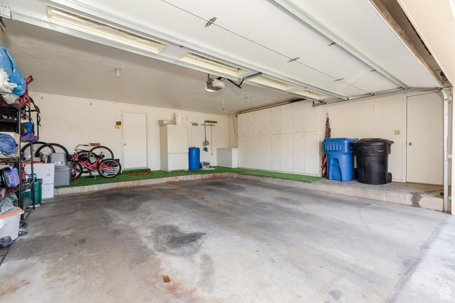 Garage featuring freestanding refrigerator and a garage door opener | Image 33