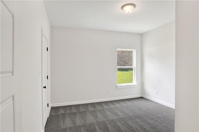 Spare room with baseboards and dark carpet | Image 19