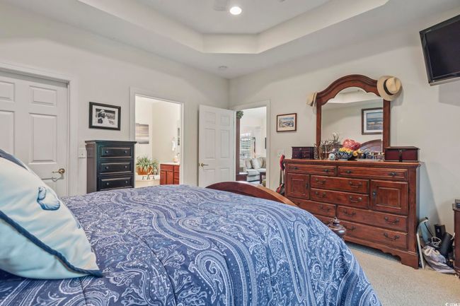 Carpeted bedroom featuring a raised ceiling and ensuite bathroom | Image 10