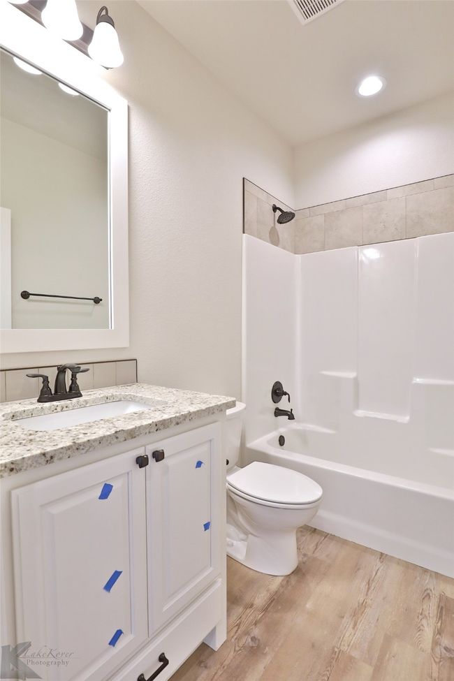 Full bathroom featuring wood finished floors, vanity, and shower / bathtub combination | Image 22