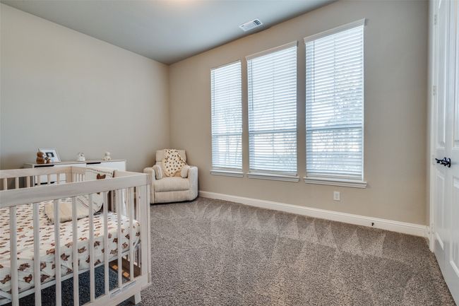 Bedroom with carpet floors and a crib | Image 22