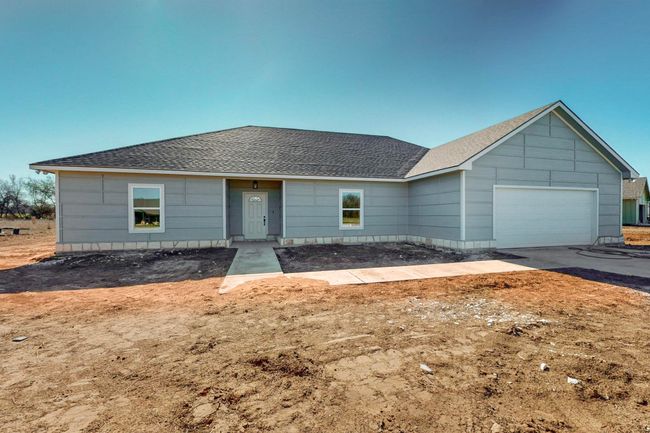 Ranch-style house featuring driveway, a shingled roof, and a garage | Image 4