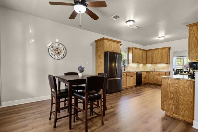 Dining space with ceiling fan, baseboards, dark wood-style floors, and visible vents | Image 8