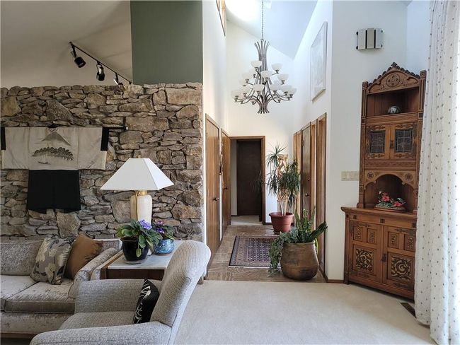 Foyer with a high ceiling, rail lighting, a notable chandelier, and carpet | Image 7