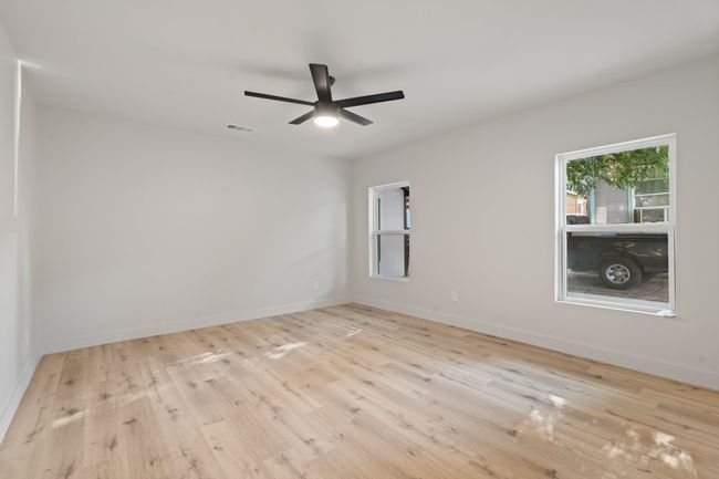Unfurnished room featuring wood finished floors, ceiling fan, and baseboards | Image 14