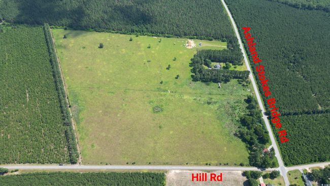Aerial view of sparsely populated area featuring a heavily wooded area and property parcel outlined | Image 9