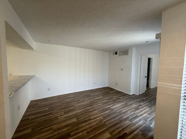 Unfurnished room featuring dark wood-style flooring and a textured ceiling | Image 4
