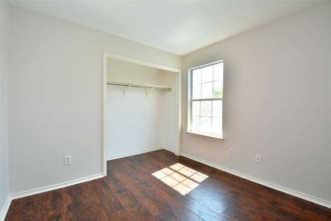 Unfurnished bedroom featuring wood finished floors, a closet, and baseboards | Image 17