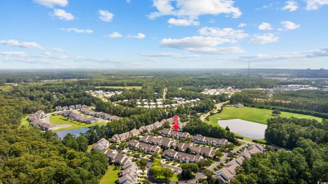 Aerial perspective of suburban area featuring a nearby body of water and a local golf course | Image 40
