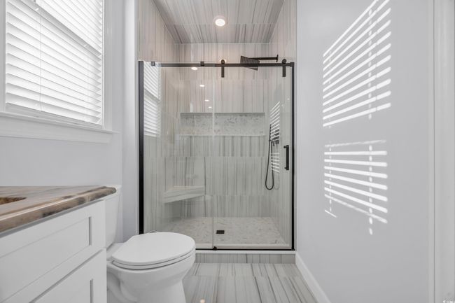 Bathroom featuring toilet, a stall shower, vanity, and baseboards | Image 20