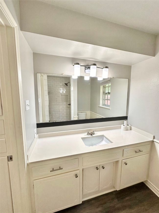 Full bathroom featuring tiled shower, vanity, and wood finished floors | Image 20