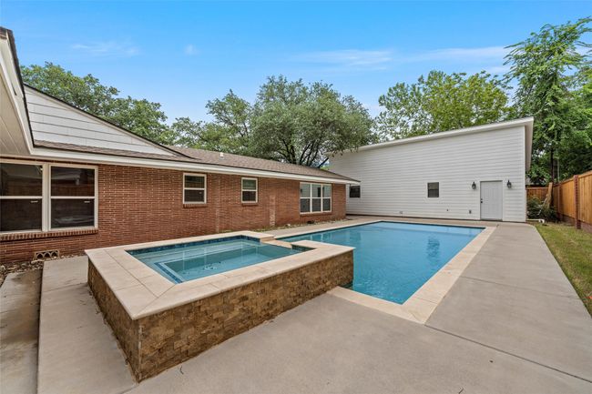 View of swimming pool featuring an in-ground hot tub, a patio area, and fence | Image 39