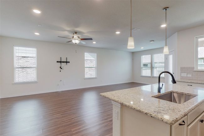Kitchen with a sink, open floor plan, wood finished floors, pendant lighting, and recessed lighting | Image 10