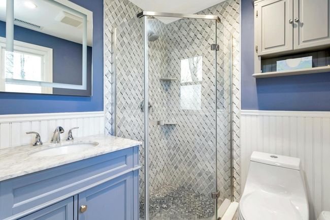 Primary bedroom fully renovated bath with marble countertop and wainscoting. | Image 17