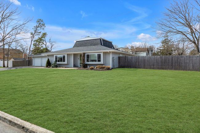 View of front of home with an attached garage, a front yard, roof with shingles, and fence | Image 19