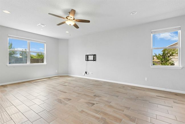 Empty room with a ceiling fan, recessed lighting, and light wood-style flooring | Image 7