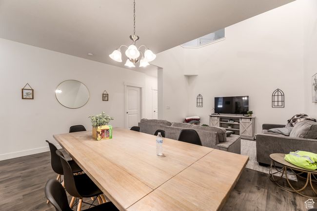 Dining area with baseboards, a notable chandelier, and dark wood finished floors | Image 9