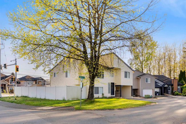 View of front of home with an attached garage, a residential view, stucco siding, fence, and a front lawn | Image 4