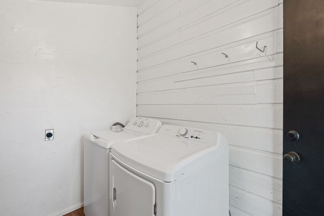 Laundry area with separate washer and dryer and wooden walls | Image 9
