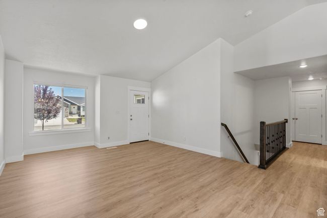Unfurnished living room featuring lofted ceiling and light wood-style floors | Image 8