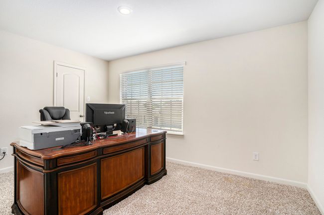 bedroom with baseboards, light colored carpet, and window. | Image 23