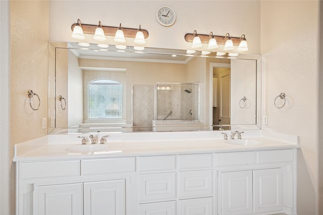 Bathroom featuring tiled shower, crown molding, and double vanity | Image 24